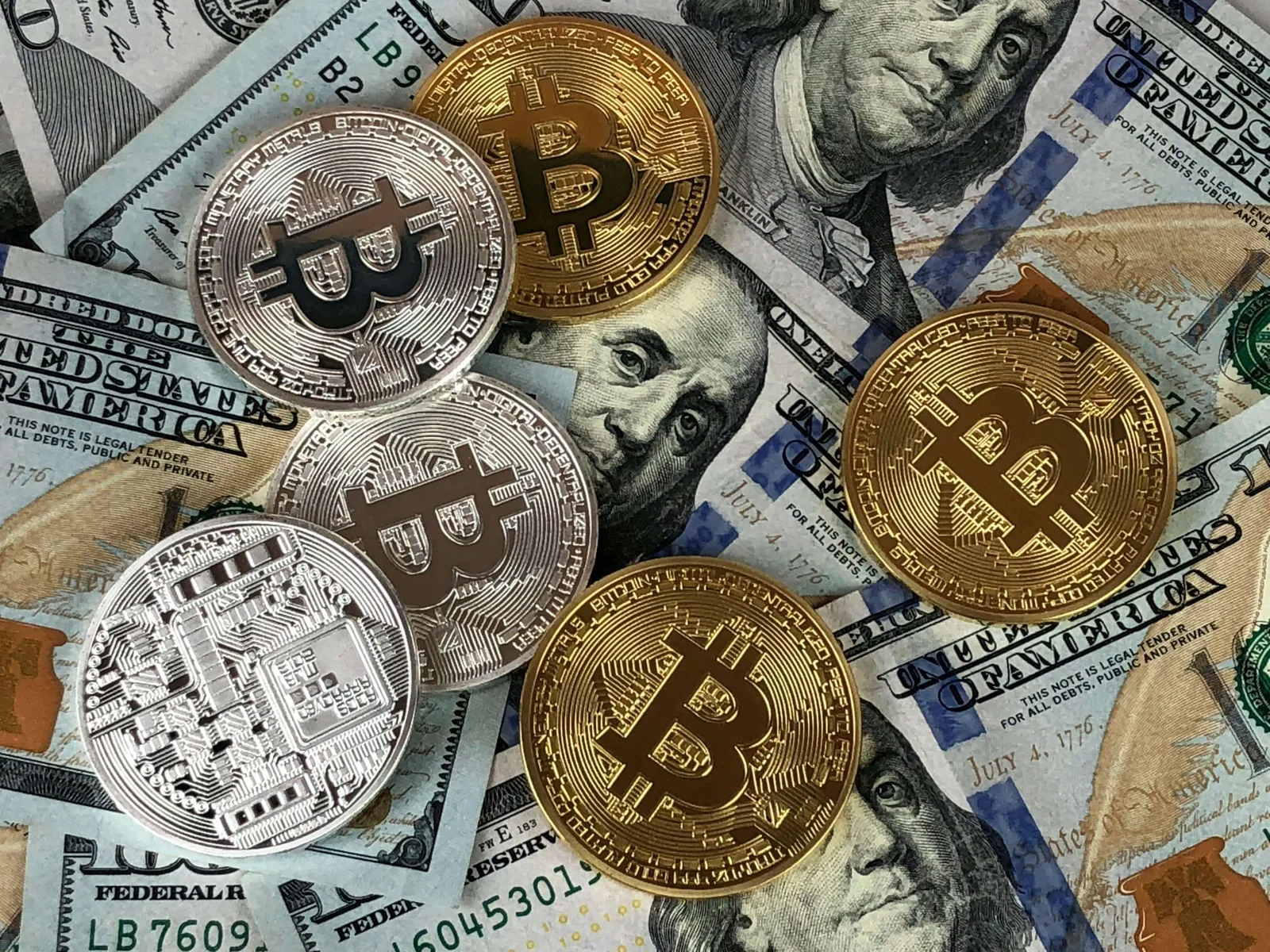 Monedas conmemorativas de bitcoin sobre billetes de dólar